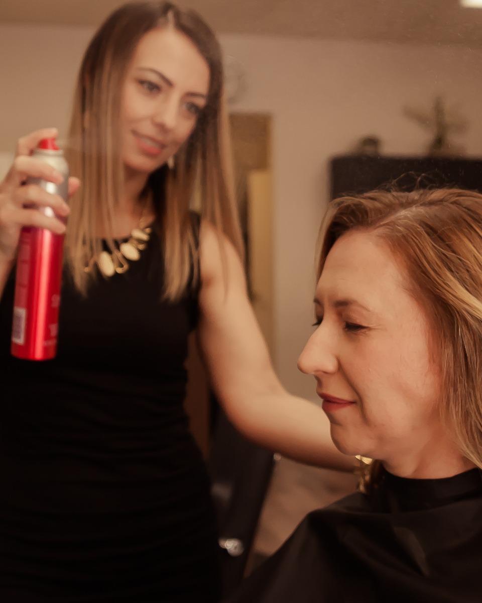 Timi finishing a client blowout with styling spray