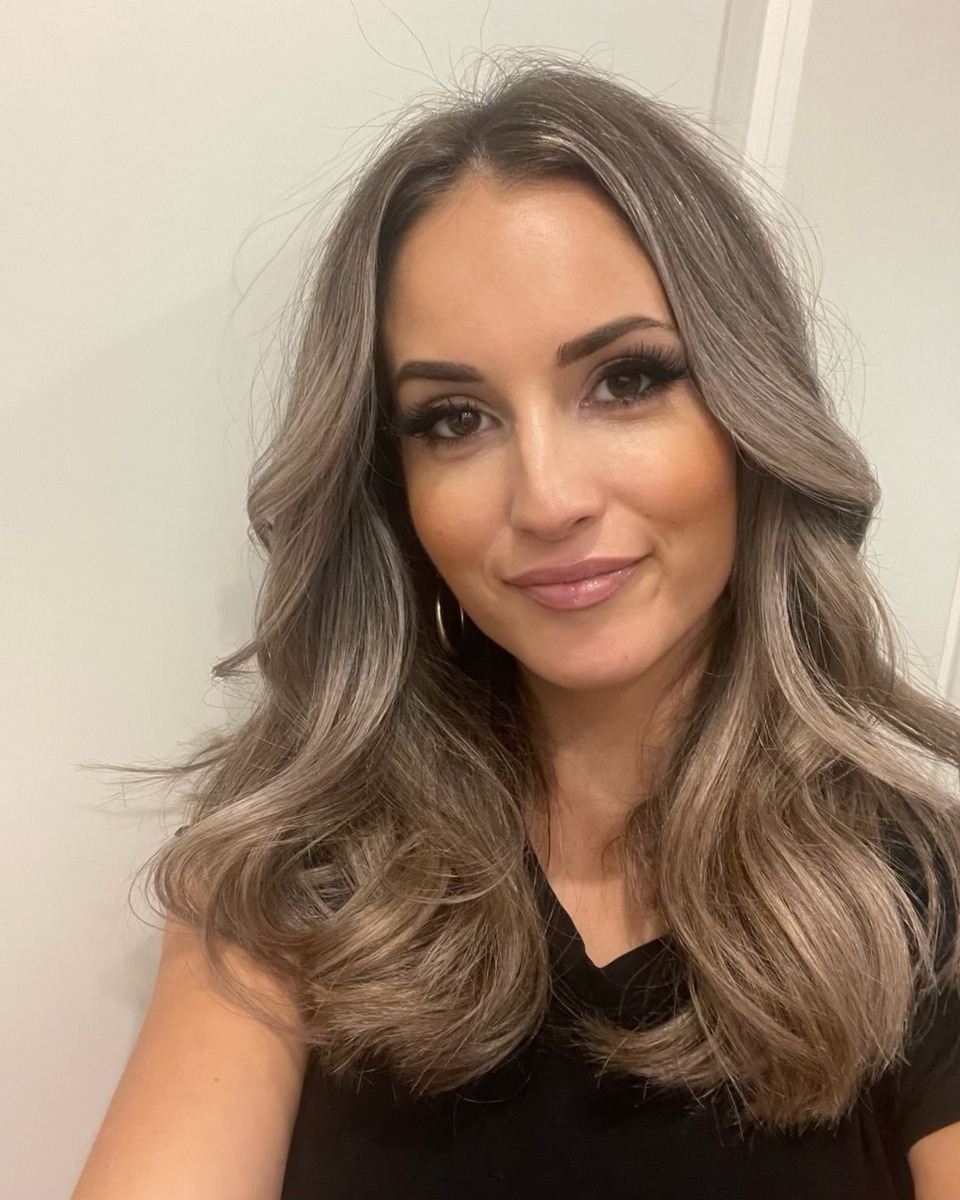 Client showing dimensional ash blonde balayage waves